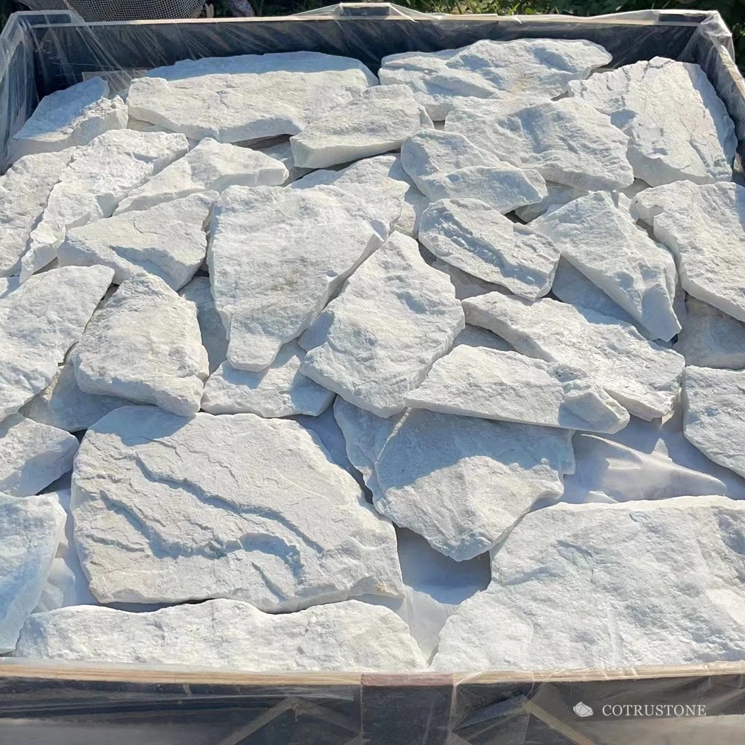 Irregular white stone cladding pieces arranged in a lined crate