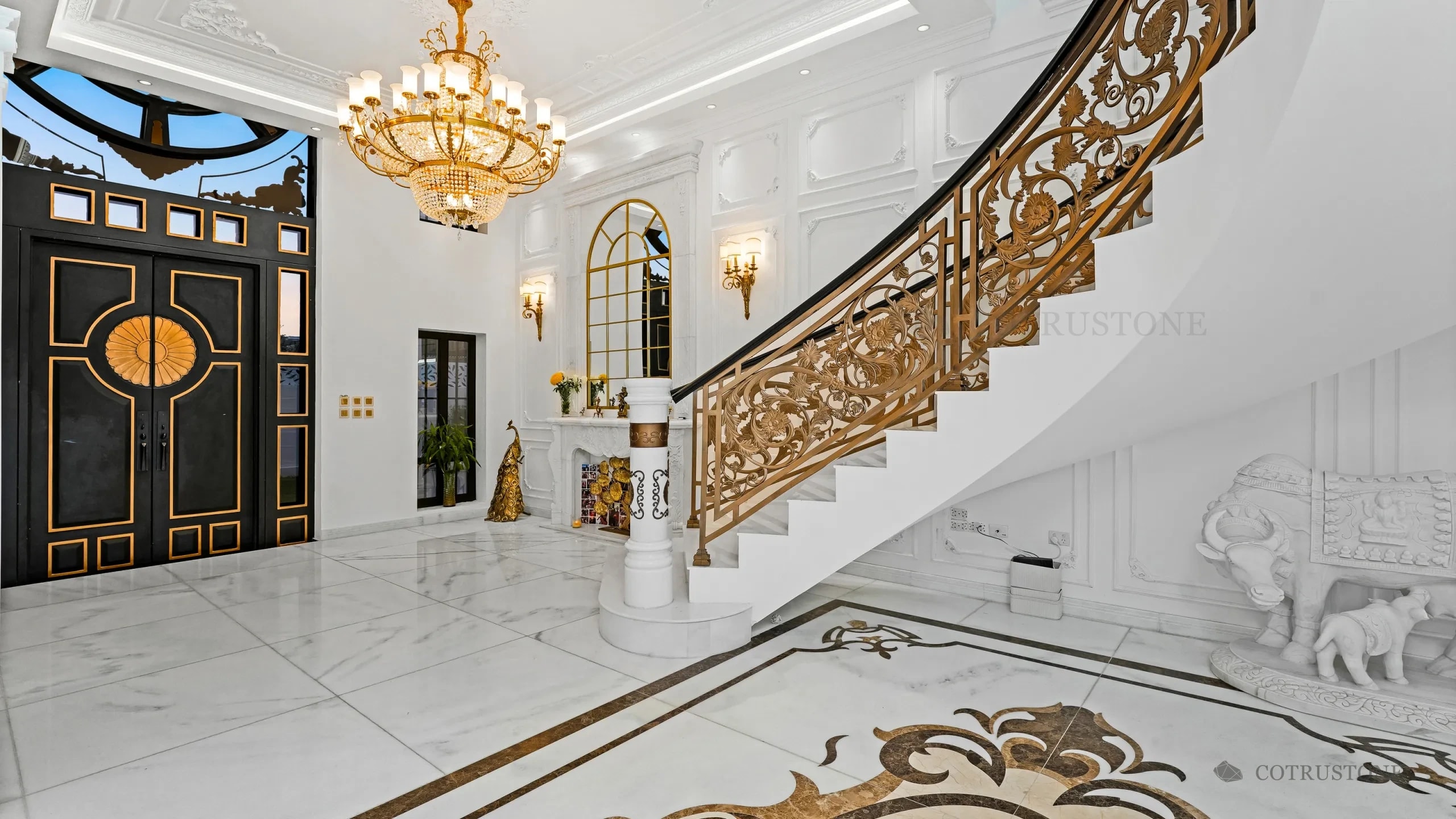 Escalera de piedra, piso de mármol con incrustaciones decorativas y detalles de piedra tallada en una residencia