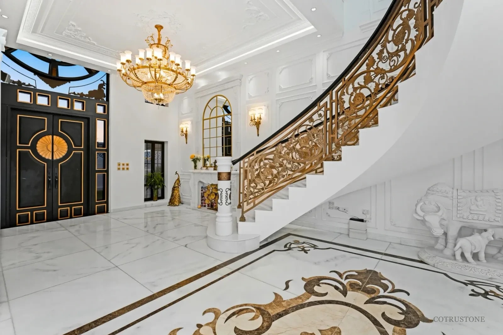 Stone stair, marble flooring with decorative inlay and carved stone details in a residence