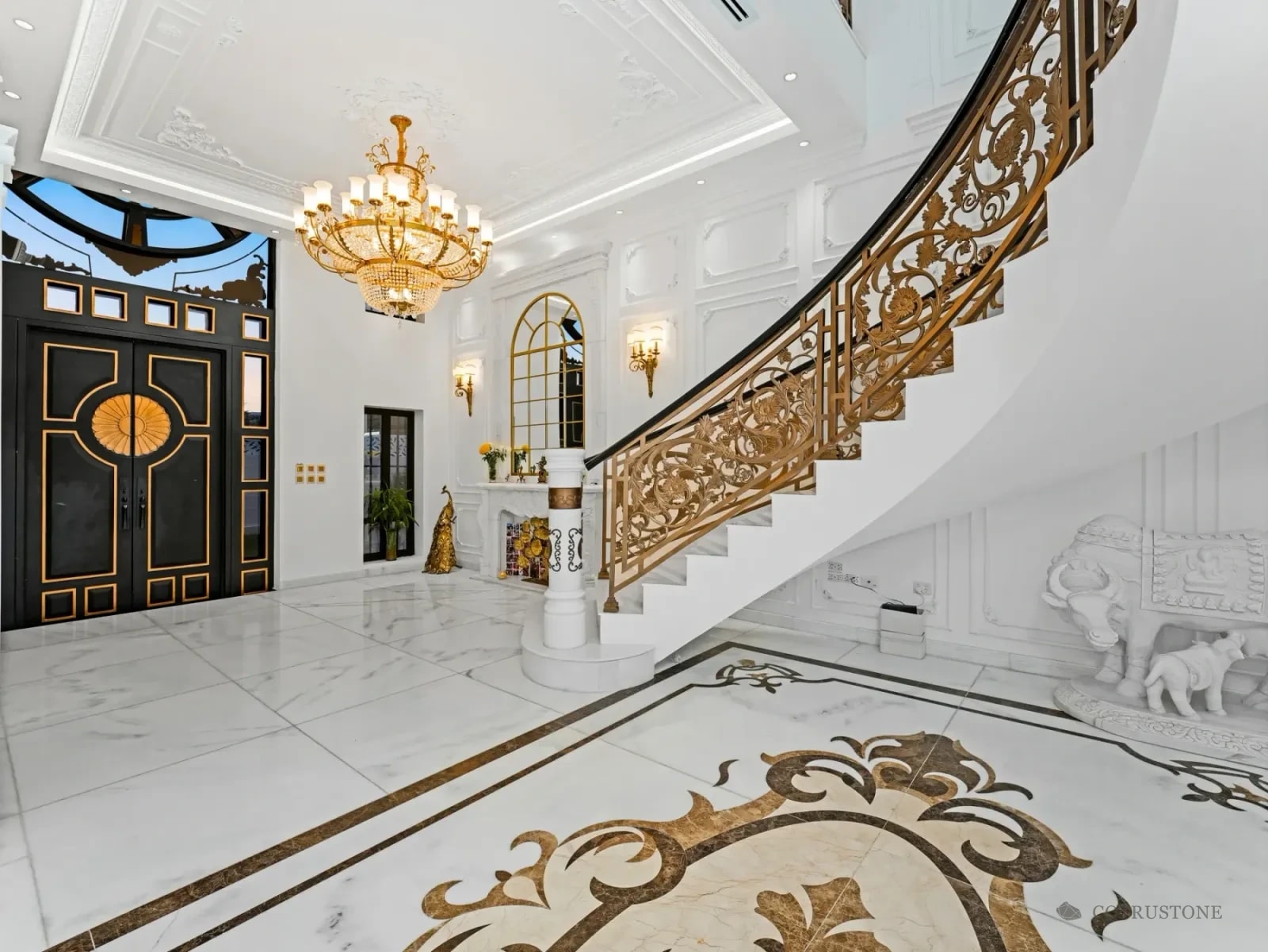 Stone stair, marble flooring with decorative inlay and carved stone details in a residence