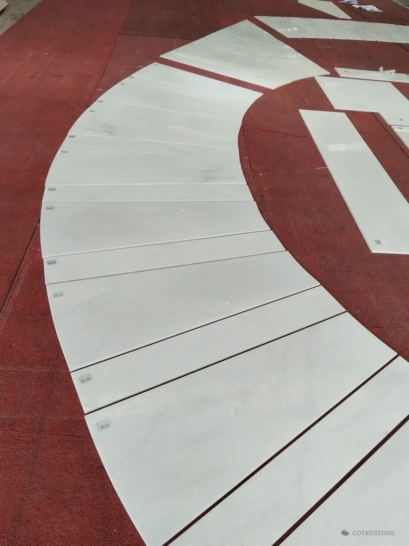 Curved marble stair treads arranged in sequence for review