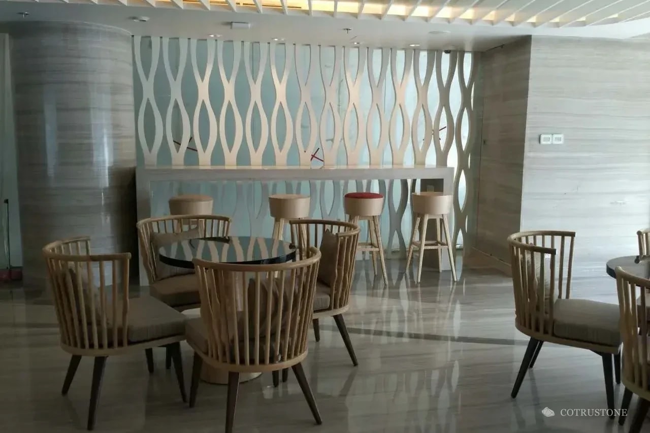 Interior de hotel con piso de piedra y revestimiento de columnas