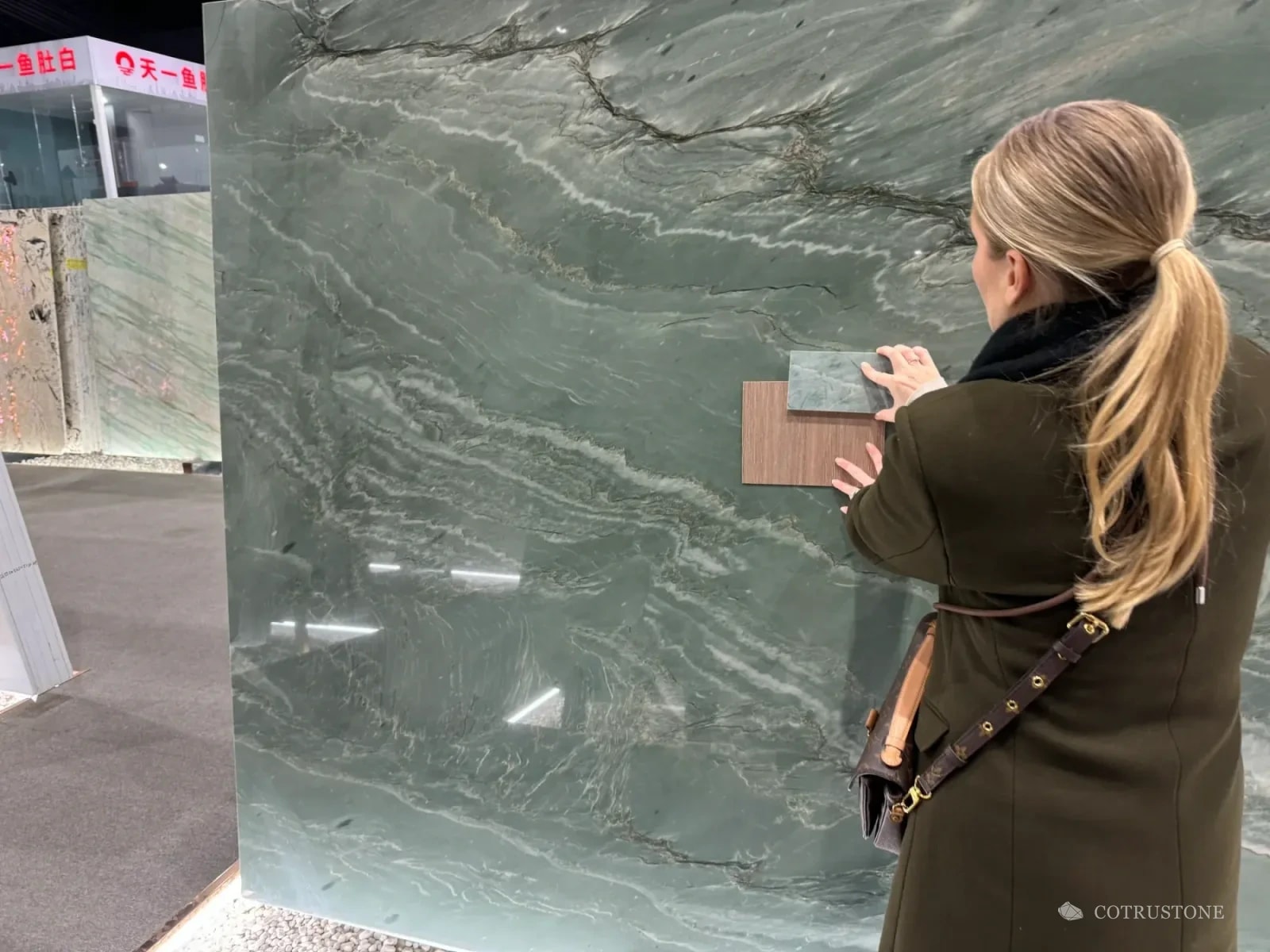 Comparing stone and wood finish samples against a full stone slab