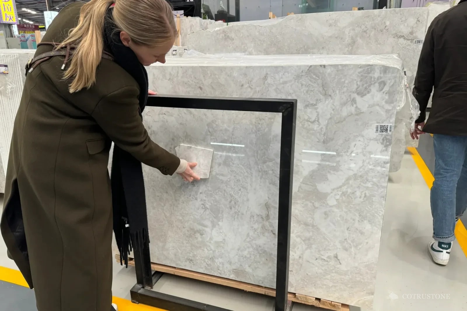 Handheld material sample compared against full-size stone