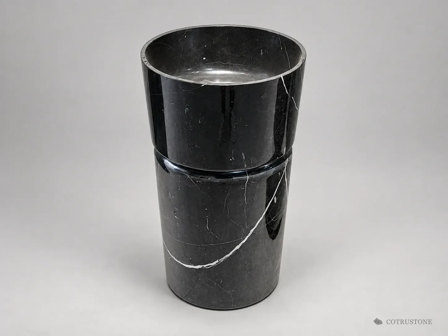 Black stone pedestal basin in a studio presentation