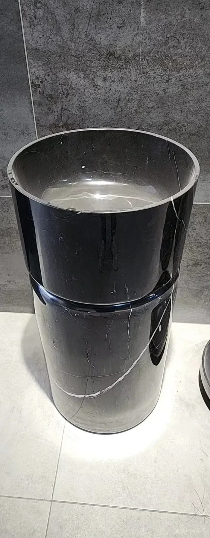 Original photograph of a dark stone pedestal basin with white veining