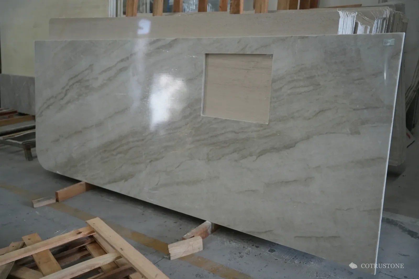 Finished stone countertop with sink opening and rounded end on workshop supports