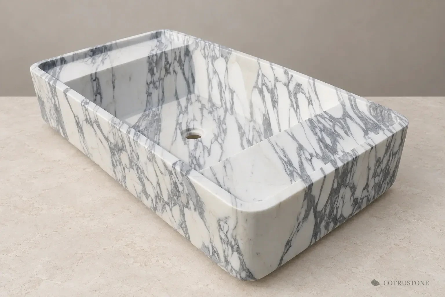 Rounded rectangular stone basin with grey veining and an integral bowl