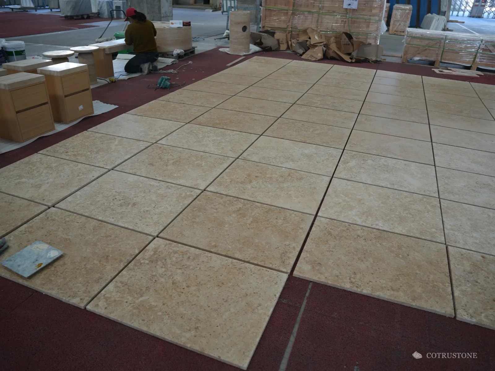 Cream limestone floor tiles laid out in full on the workshop floor