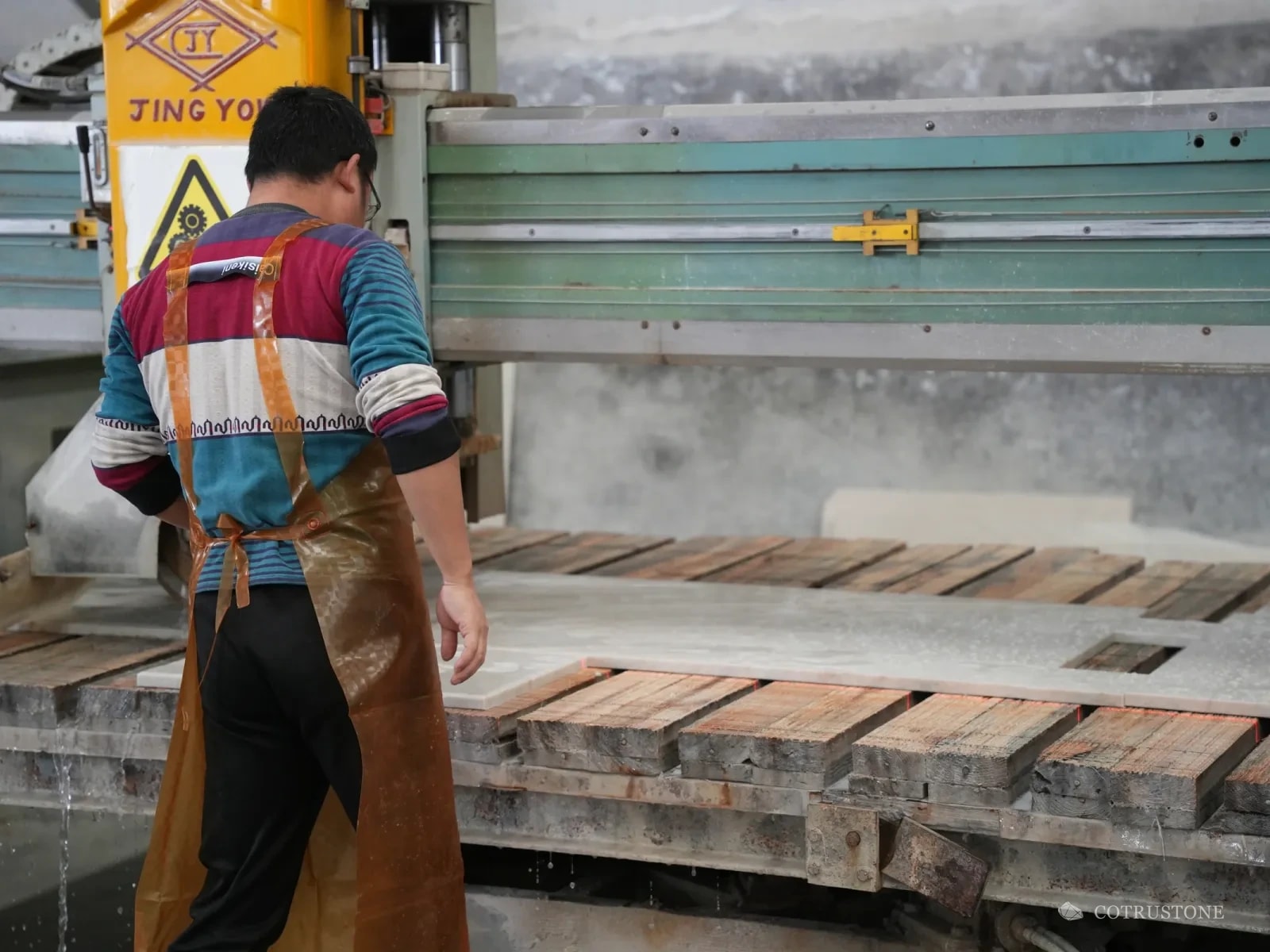Worker at a bridge saw cutting stone pieces to size