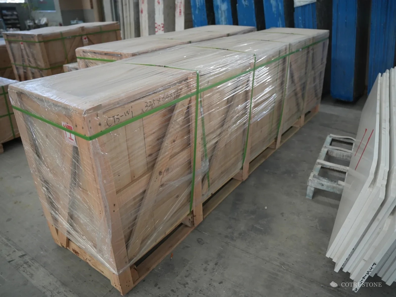 Long timber crate wrapped in film and strapped, ready for shipping