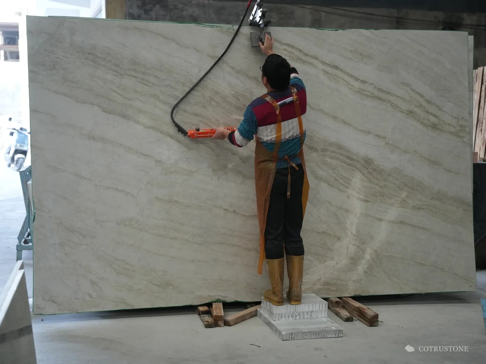 Worker washing down a large marble slab before it is photographed
