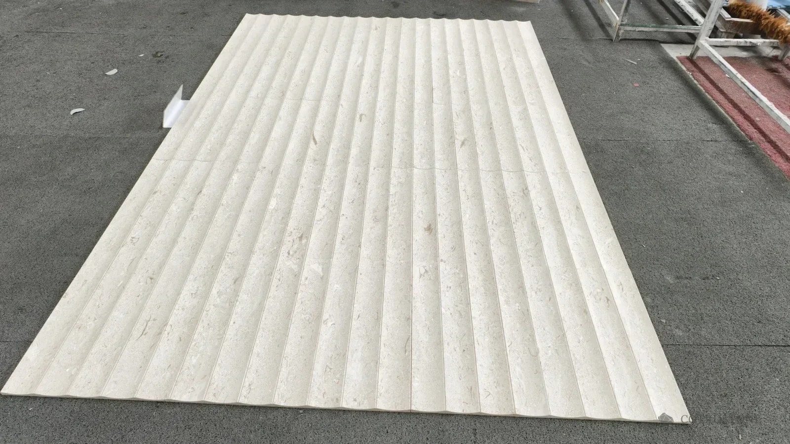 Pale carved stone panels laid together to review the repeating curved profile