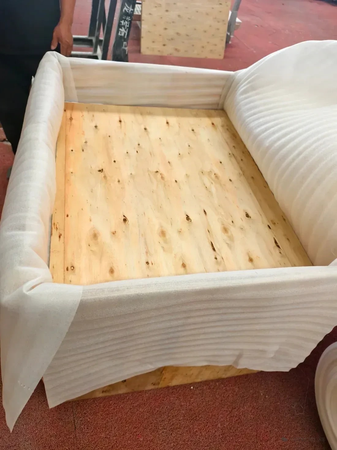 Open timber crate showing protective foam lining along the walls