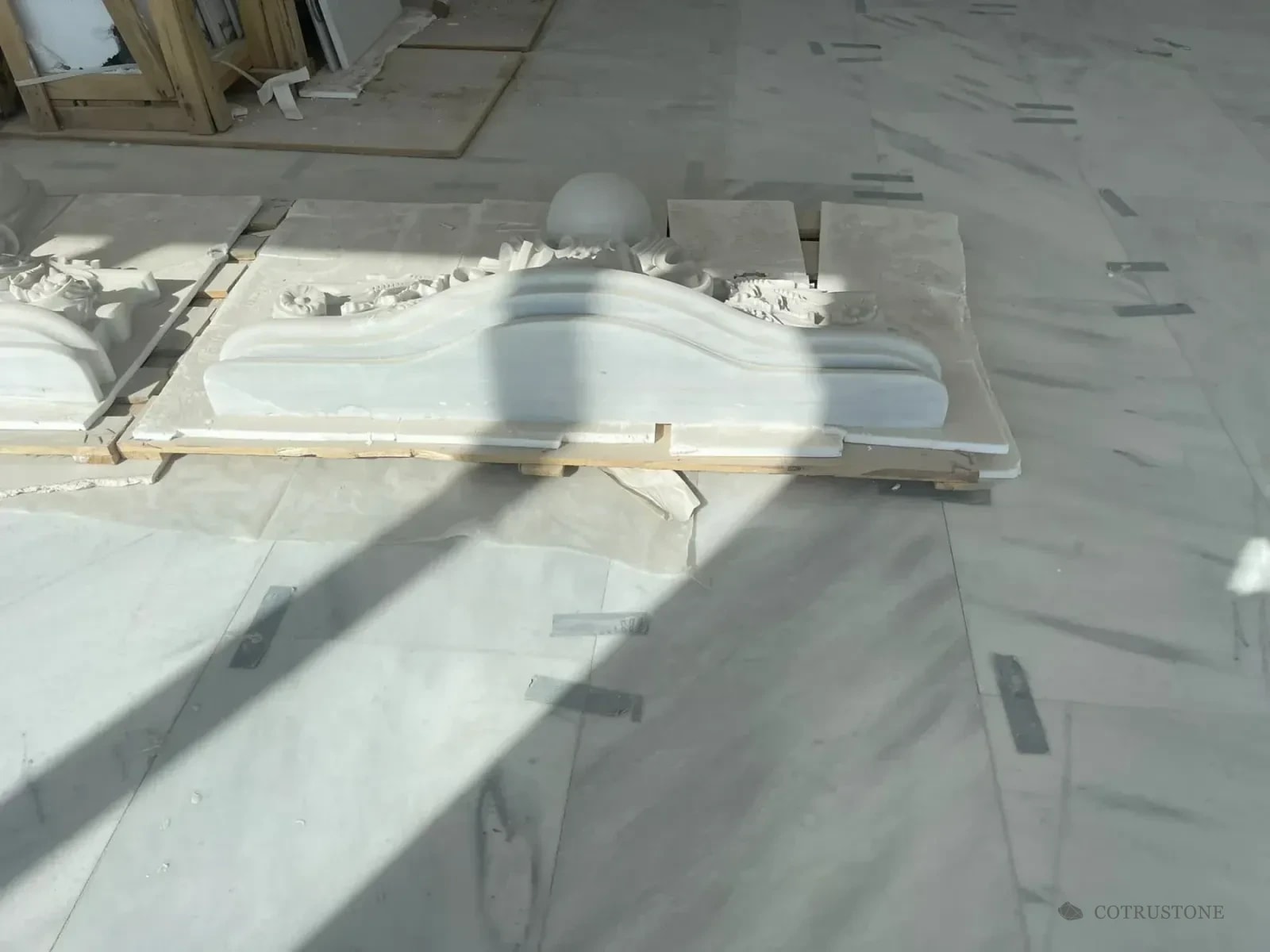 Carved architectural stone component on the marble floor during venue installation
