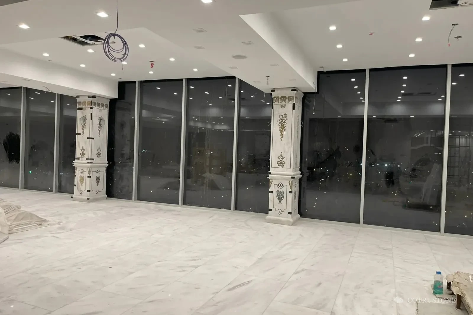 Marble flooring and decorated stone columns during installation at a wedding and event venue