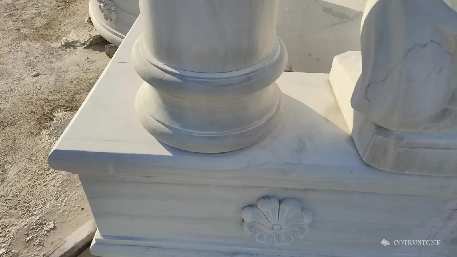 Profiled stone column base, curved basin wall and carved floral rosette during fountain assembly