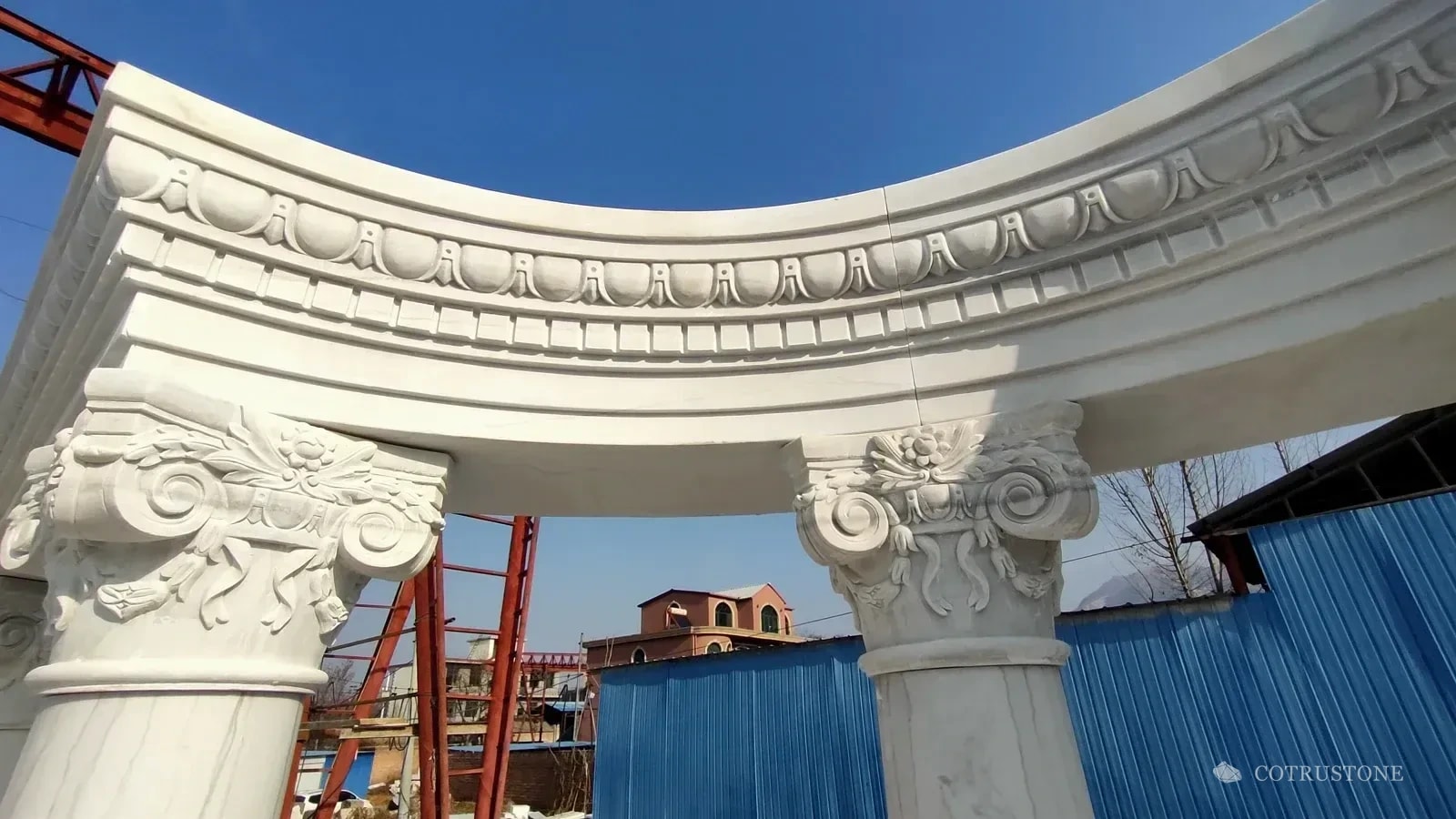 Close view of carved stone capitals and curved cornice joints