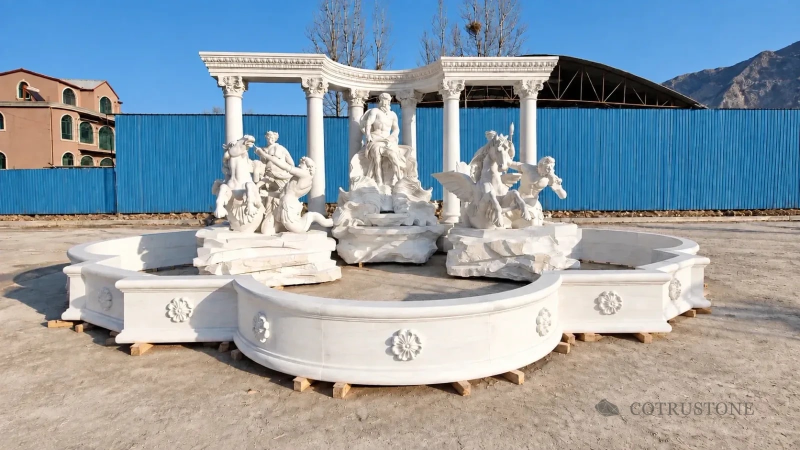 Complete carved fountain with figurative sculpture and curved colonnade