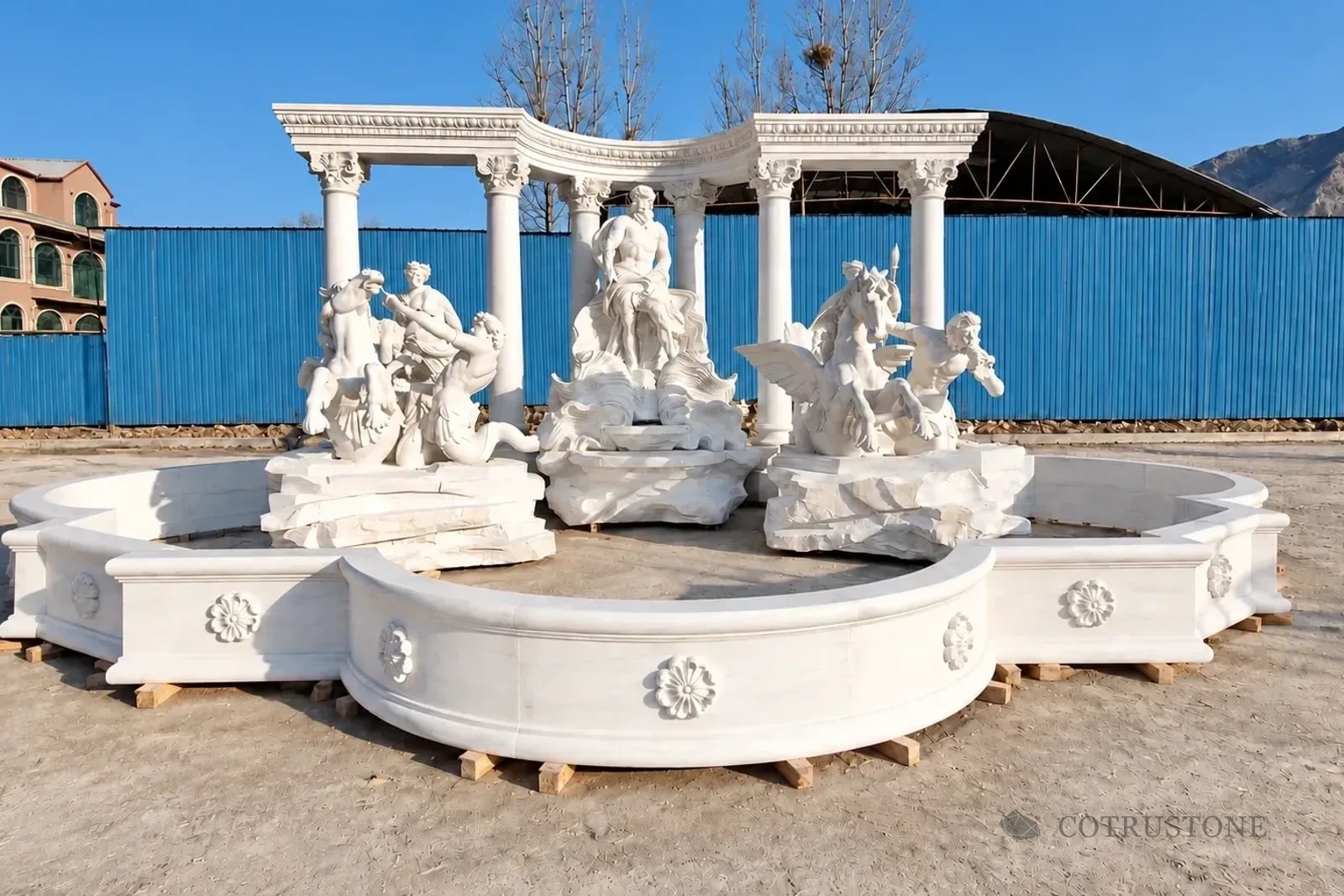 Complete carved fountain with figurative sculpture and curved colonnade