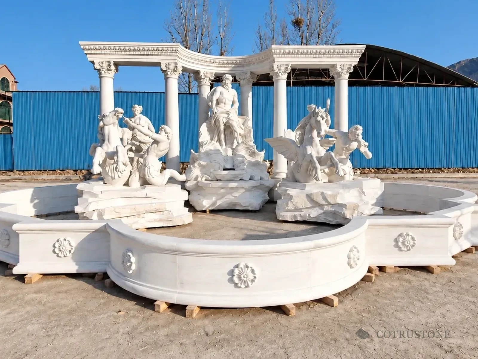 Complete carved fountain with figurative sculpture and curved colonnade