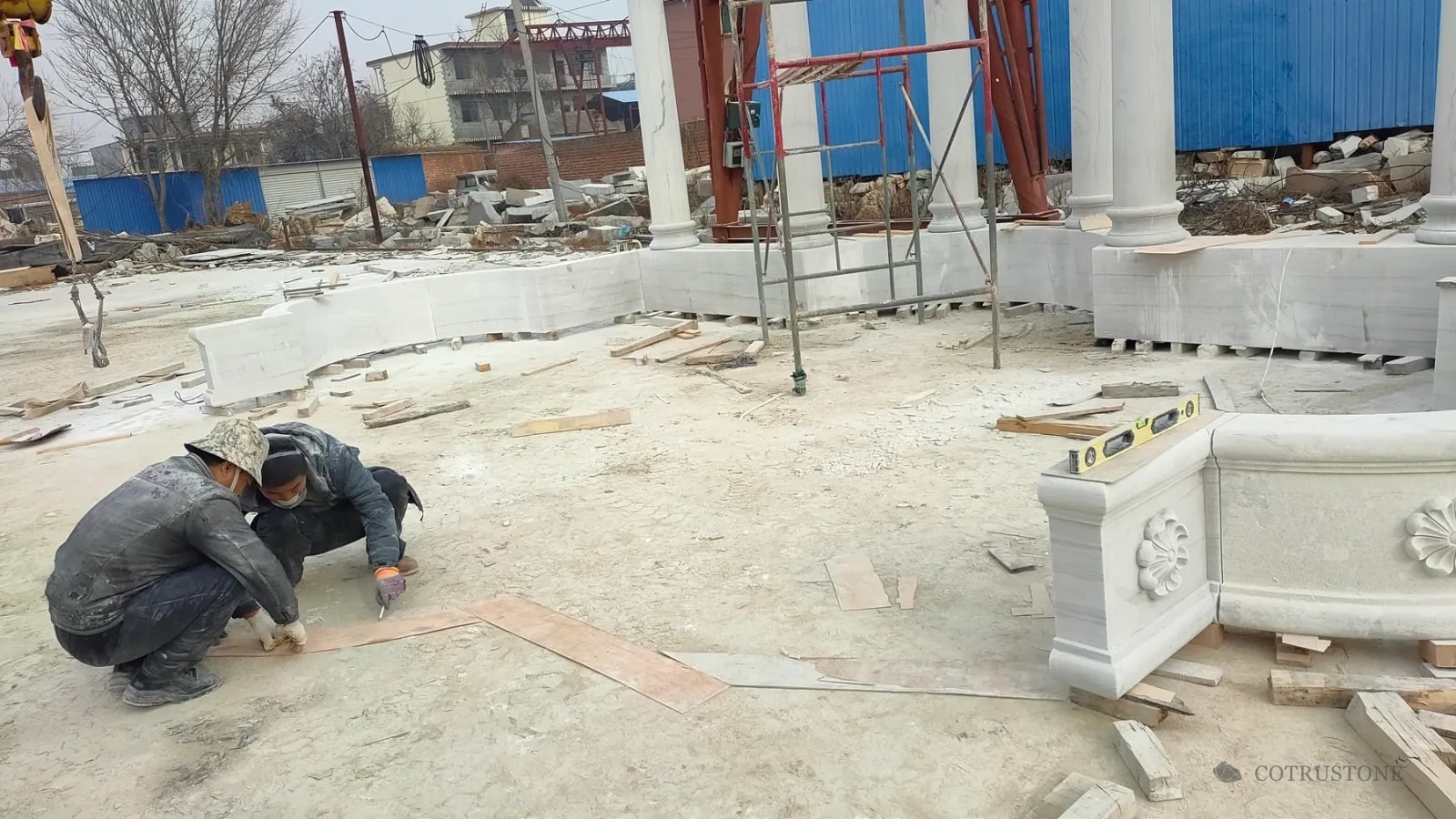 Workshop team reviewing the curved fountain footprint beside separate basin sections