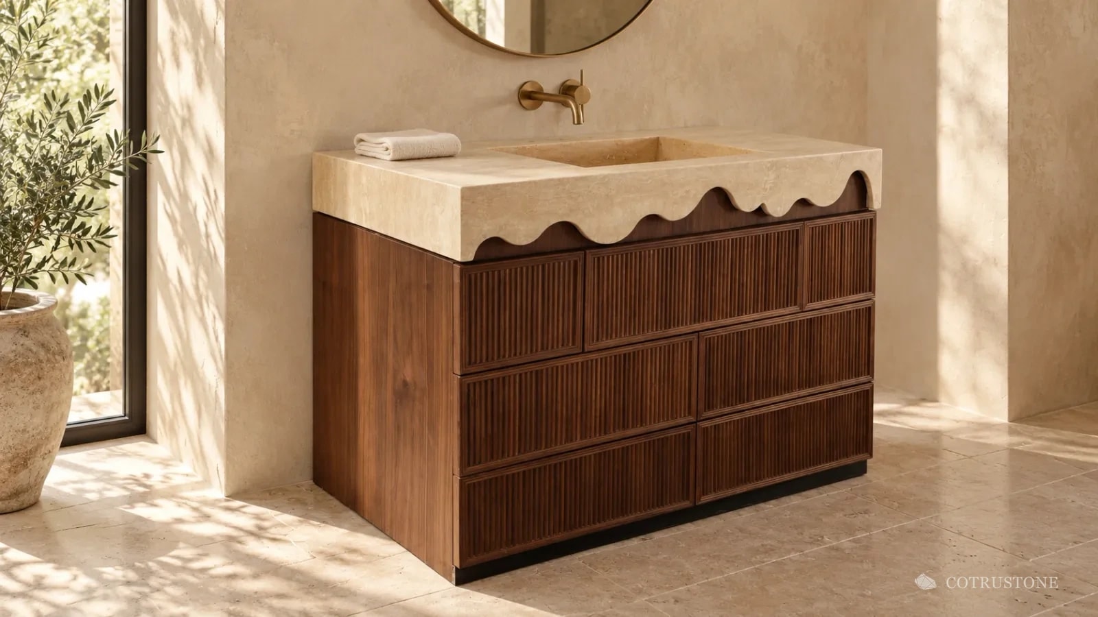 Stone vanity top with a wave-cut front edge and integrated basin over fluted timber drawers, in a sunlit bathroom