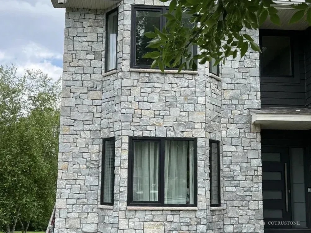 Grey stone wall cladding around the windows of a residence