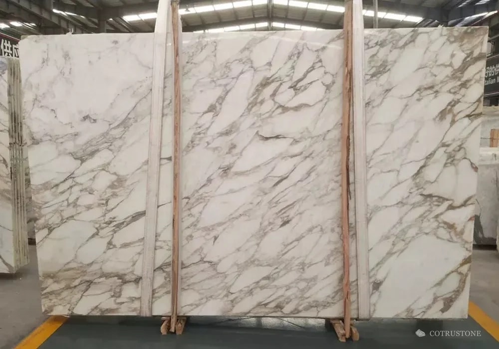 Calacatta Altissimo marble slabs with grey movement and warm-toned accents on a white ground