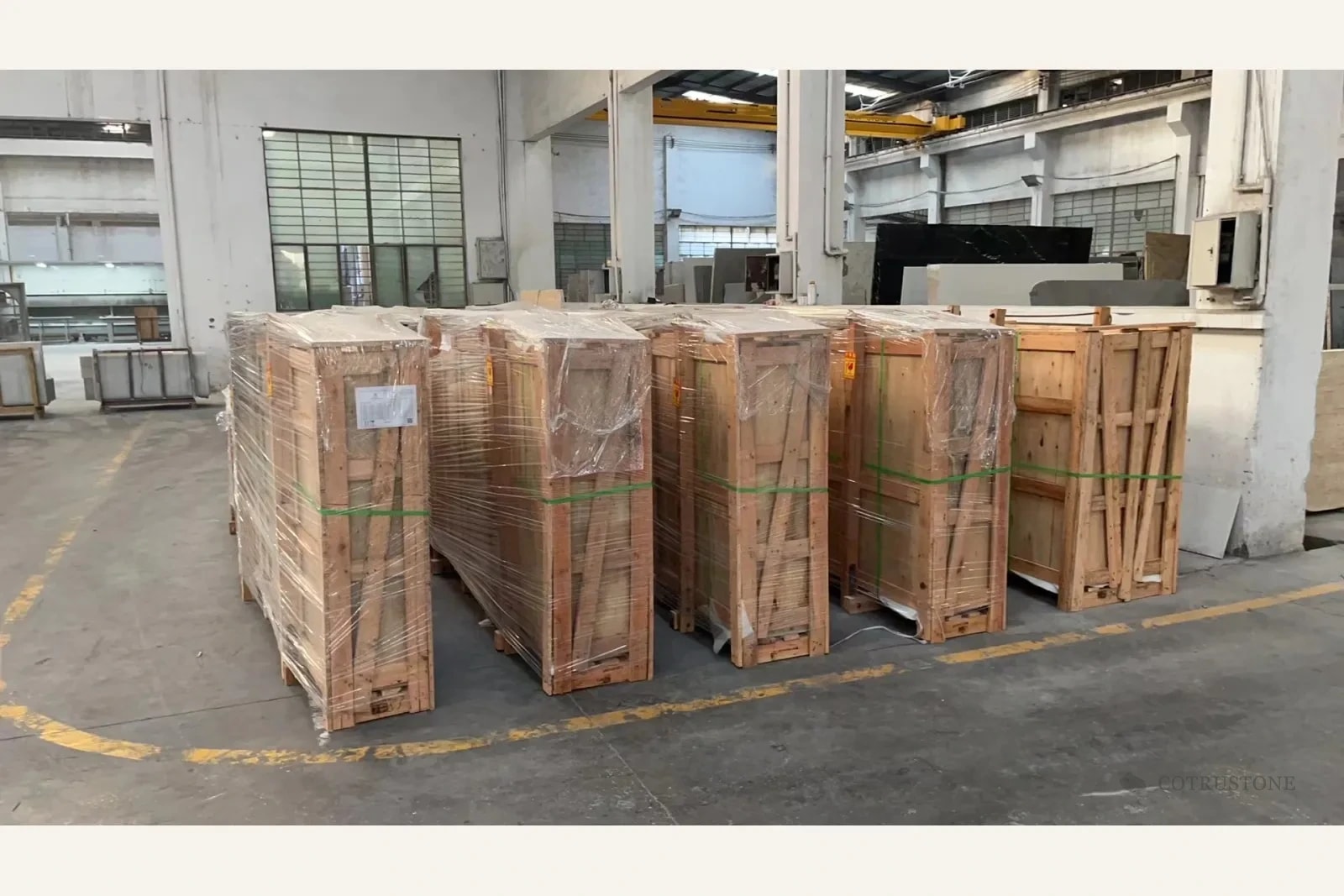 Group of closed plywood panel cases with wrapping and straps in the workshop