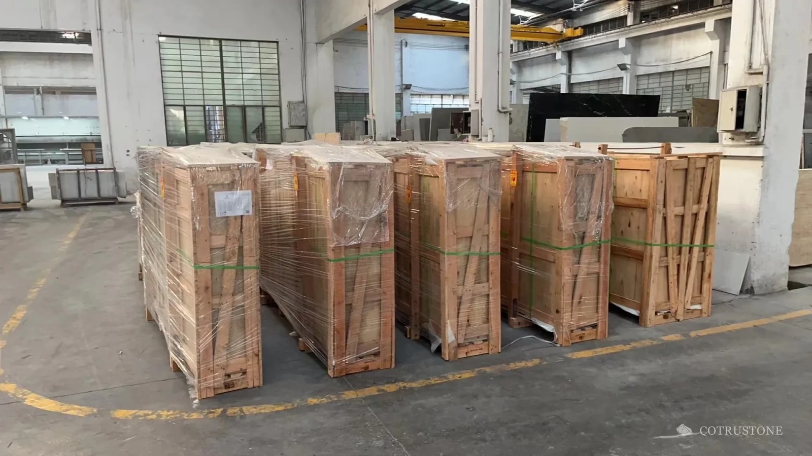 Group of closed plywood panel cases with wrapping and straps in the workshop