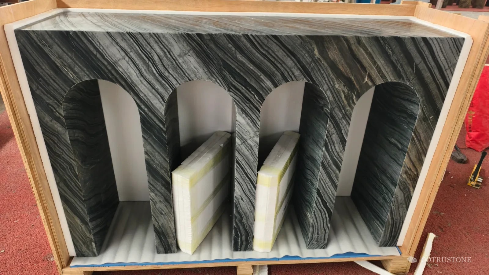 Arched stone console inside an open foam-lined timber case
