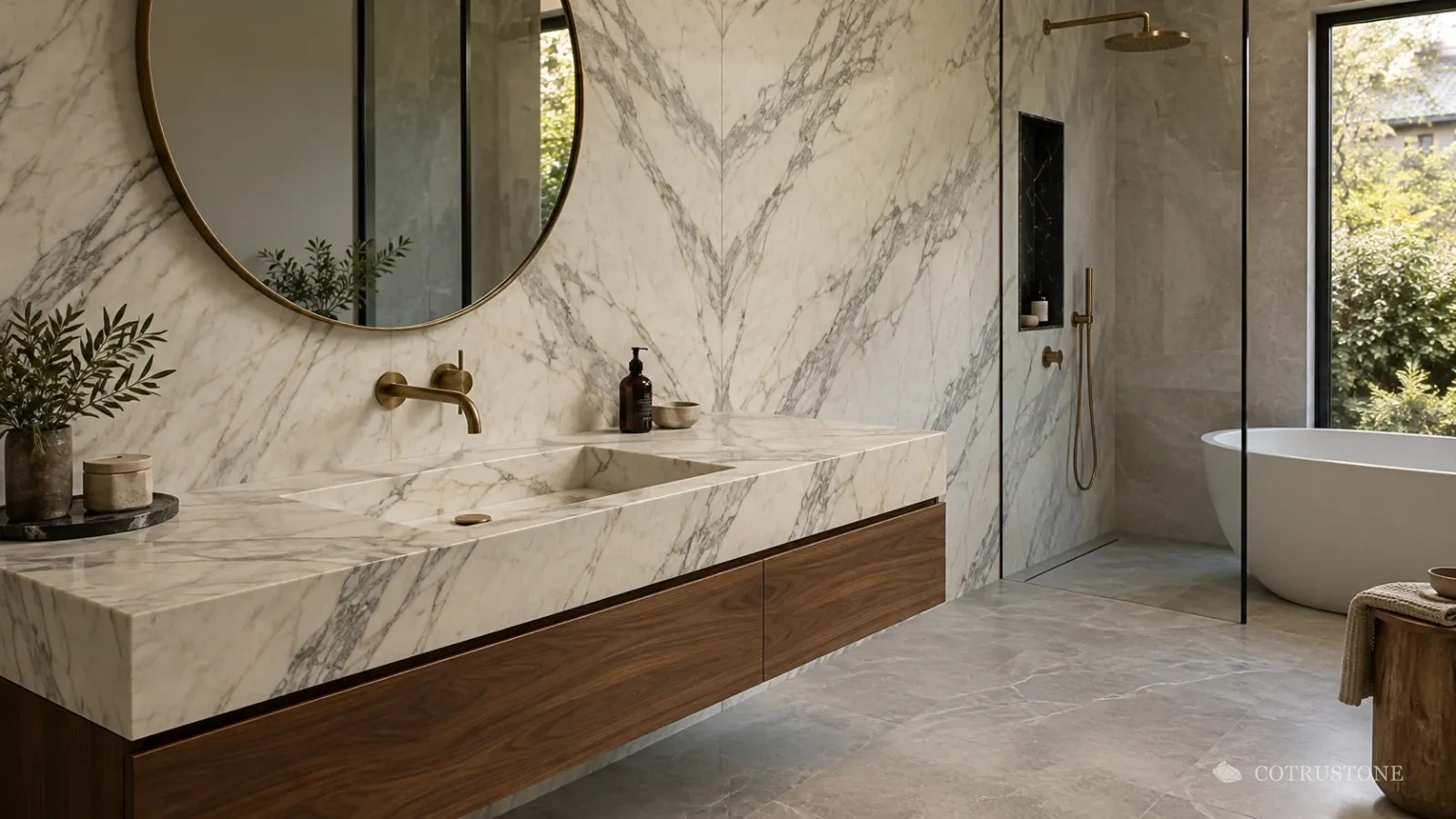 Baño con un muro de mármol Calacatta en espejo y un mueble de baño flotante con lavabo integrado en Calacatta, gabinete de nogal, grifería de latón y piso Castle Grey