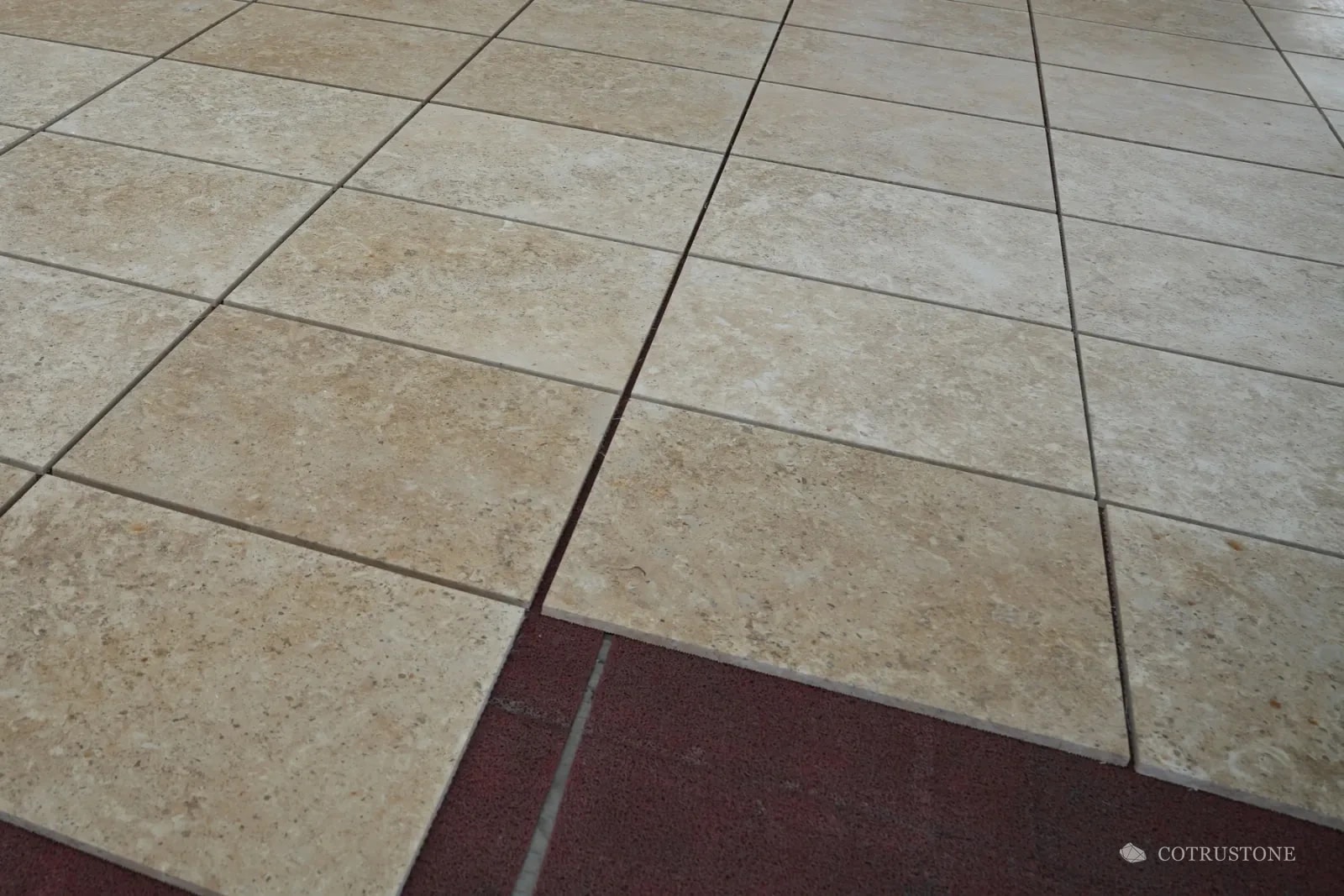 Warm-toned rectangular stone panels arranged on the workshop floor to review joints and natural variation