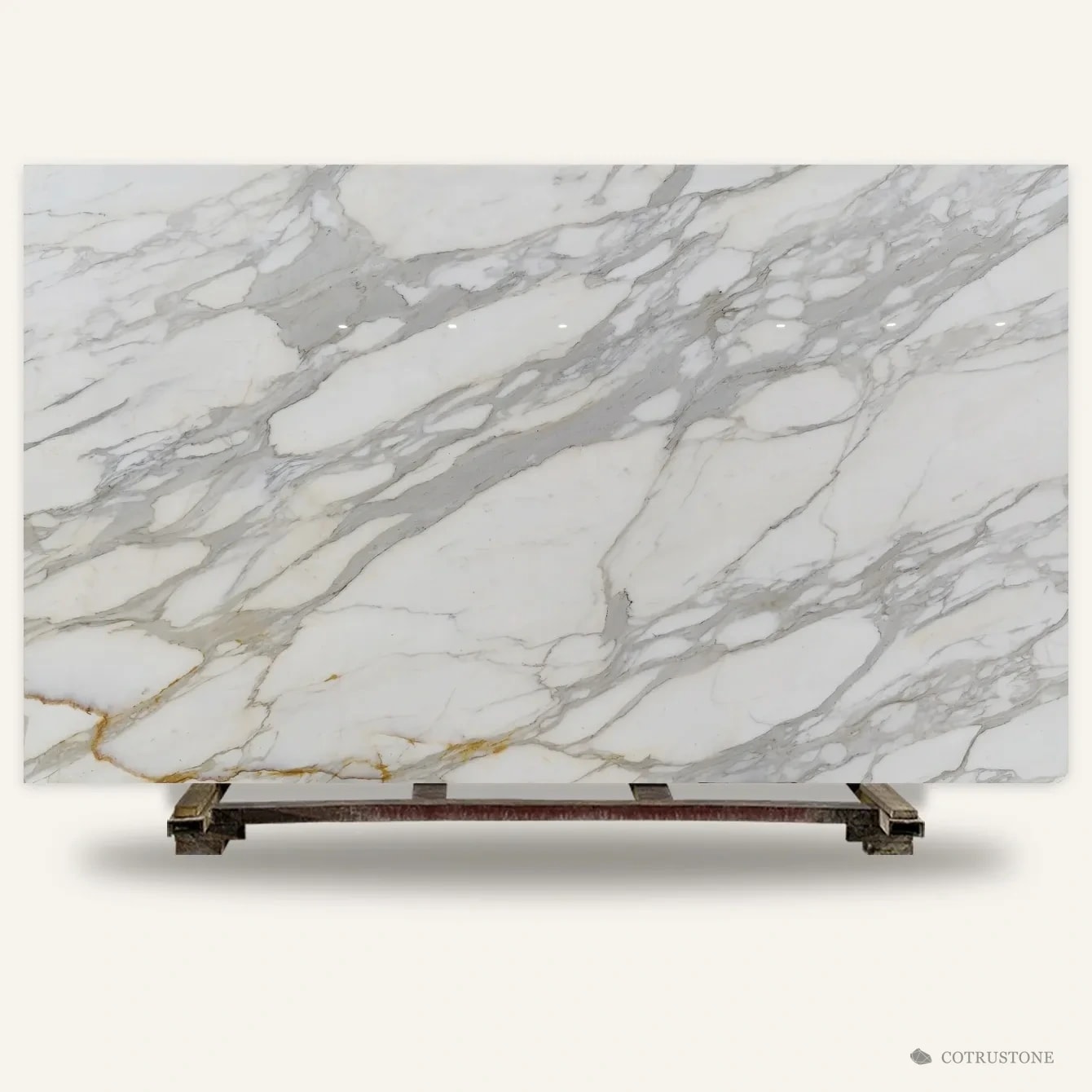 A whole slab of Calacatta marble with grey veins and gold accents, standing on a timber pallet