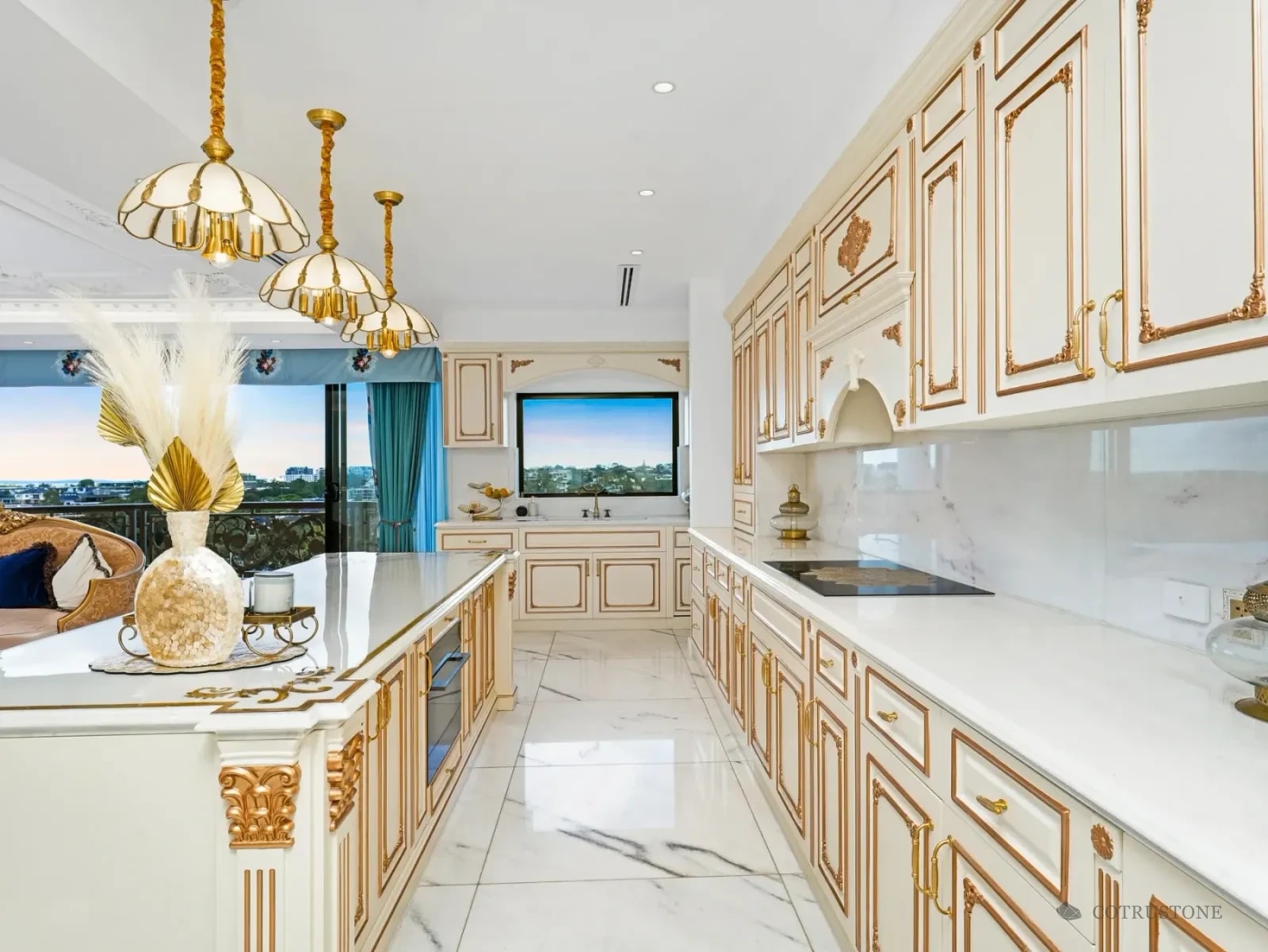 Installed kitchen with veined stone counters and coordinated marble floor surfaces