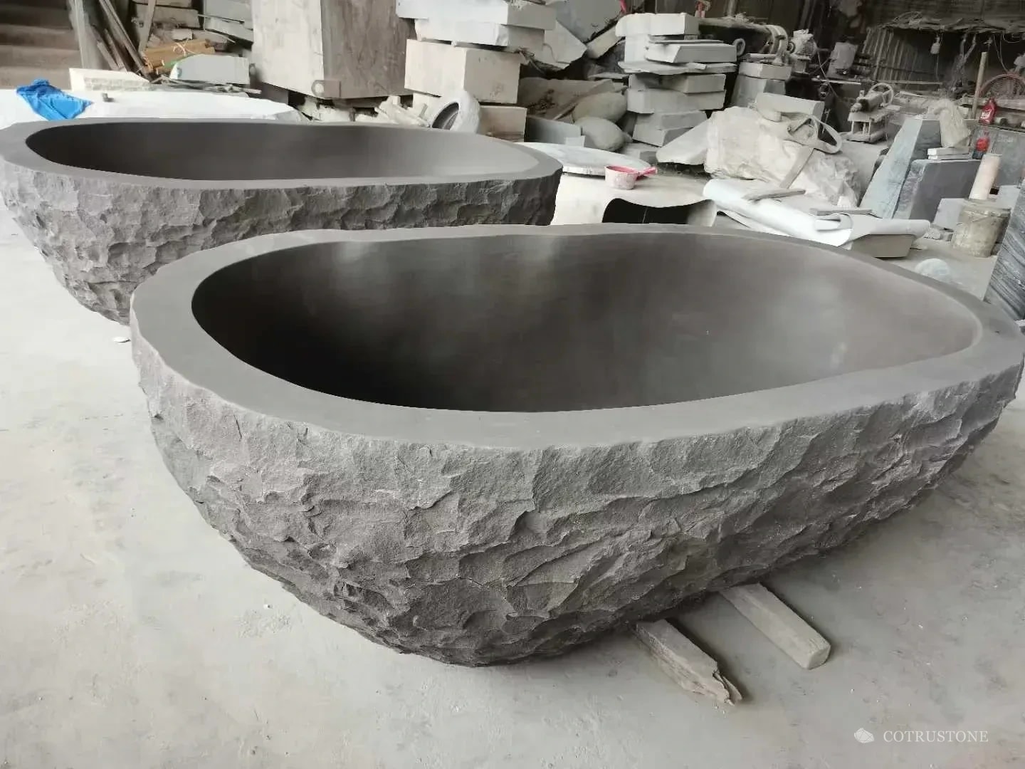 Oval stone bath with a rough exterior