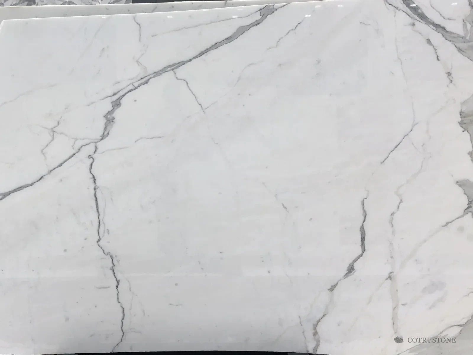 A slab of Calacatta marble, white with long grey veins crossing on the diagonal