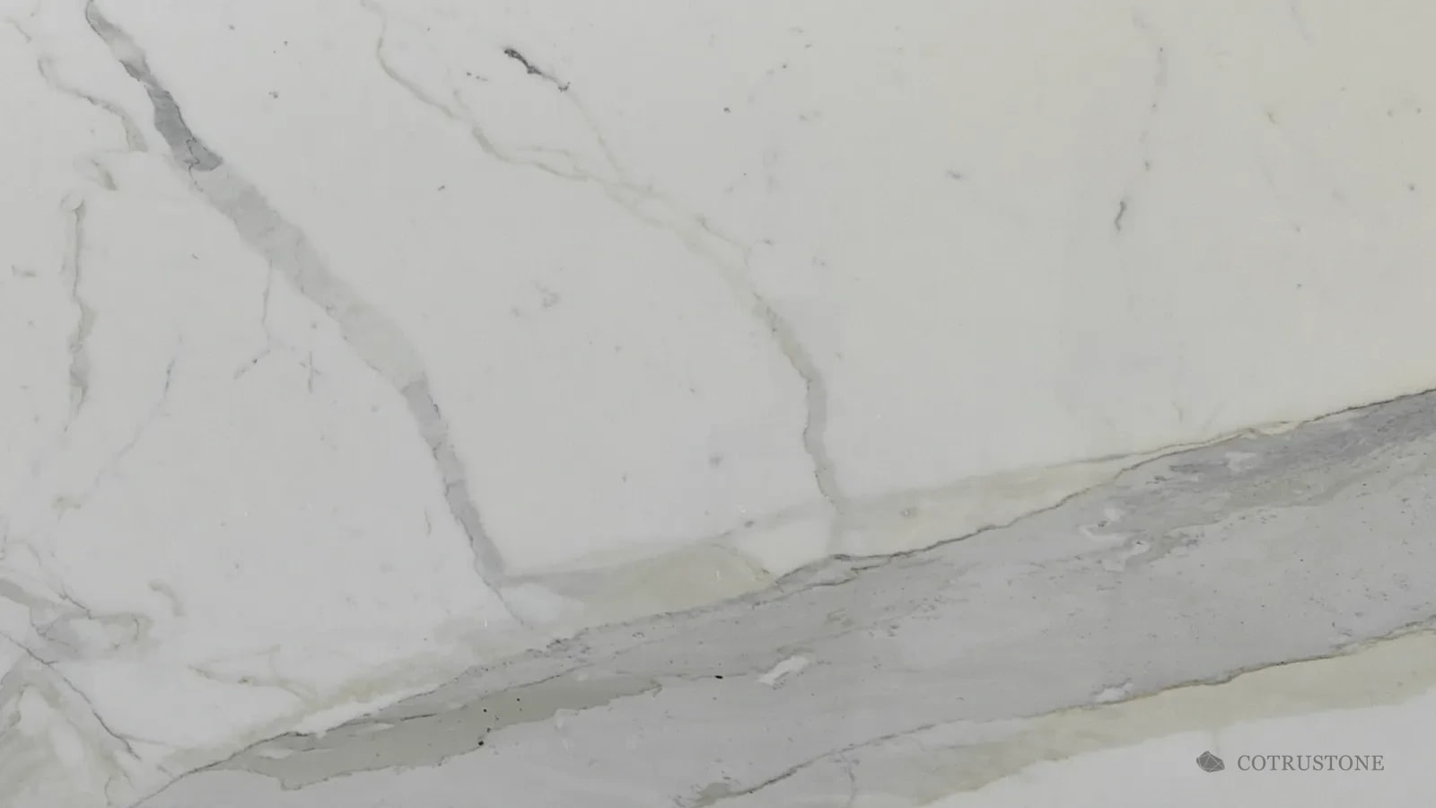 Mármol Calacatta con una banda ancha de gris y dorado pálido que cruza la placa