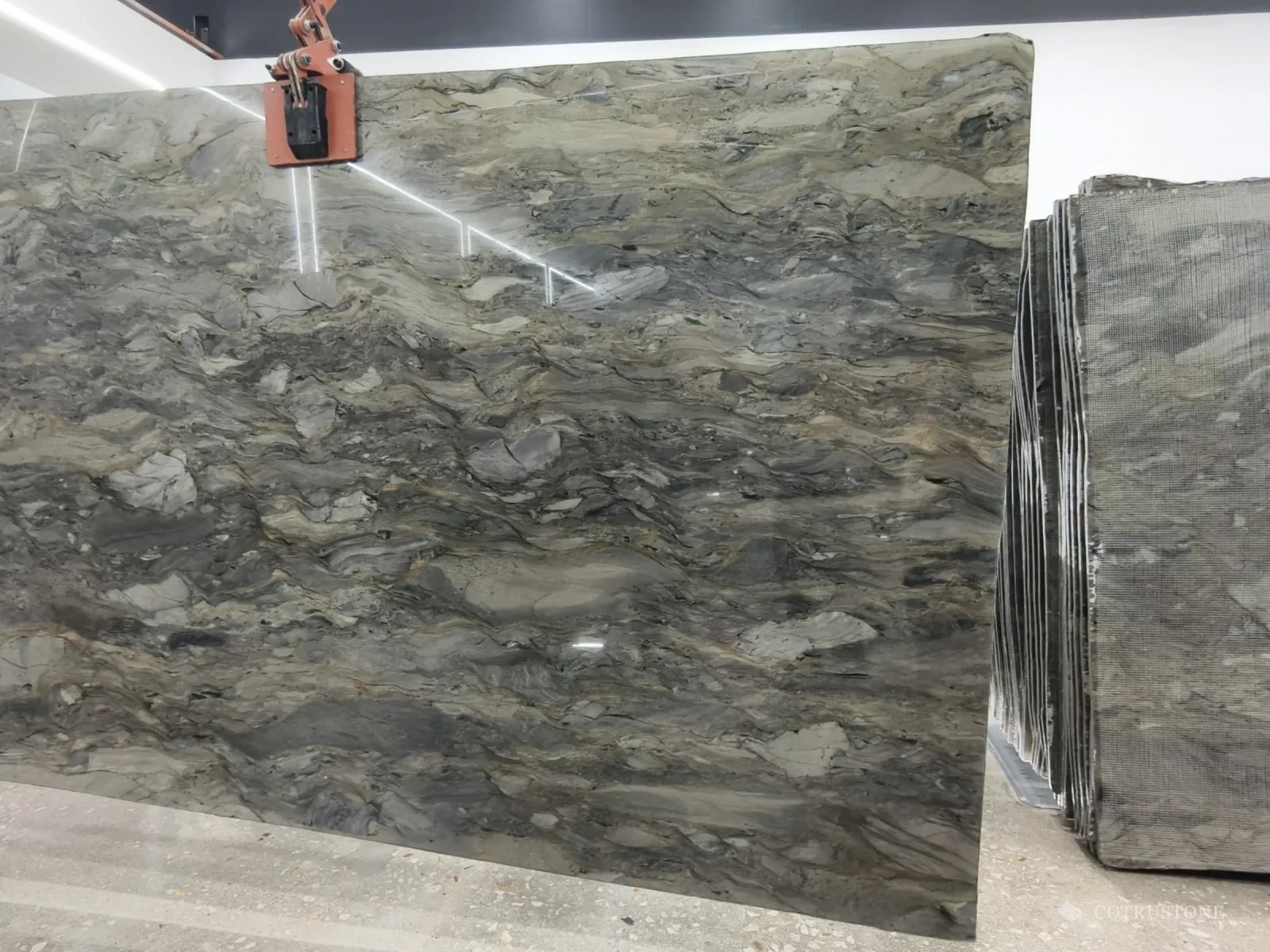 A full slab of Fusion quartzite on the stand, grey-green and beige in layered waves