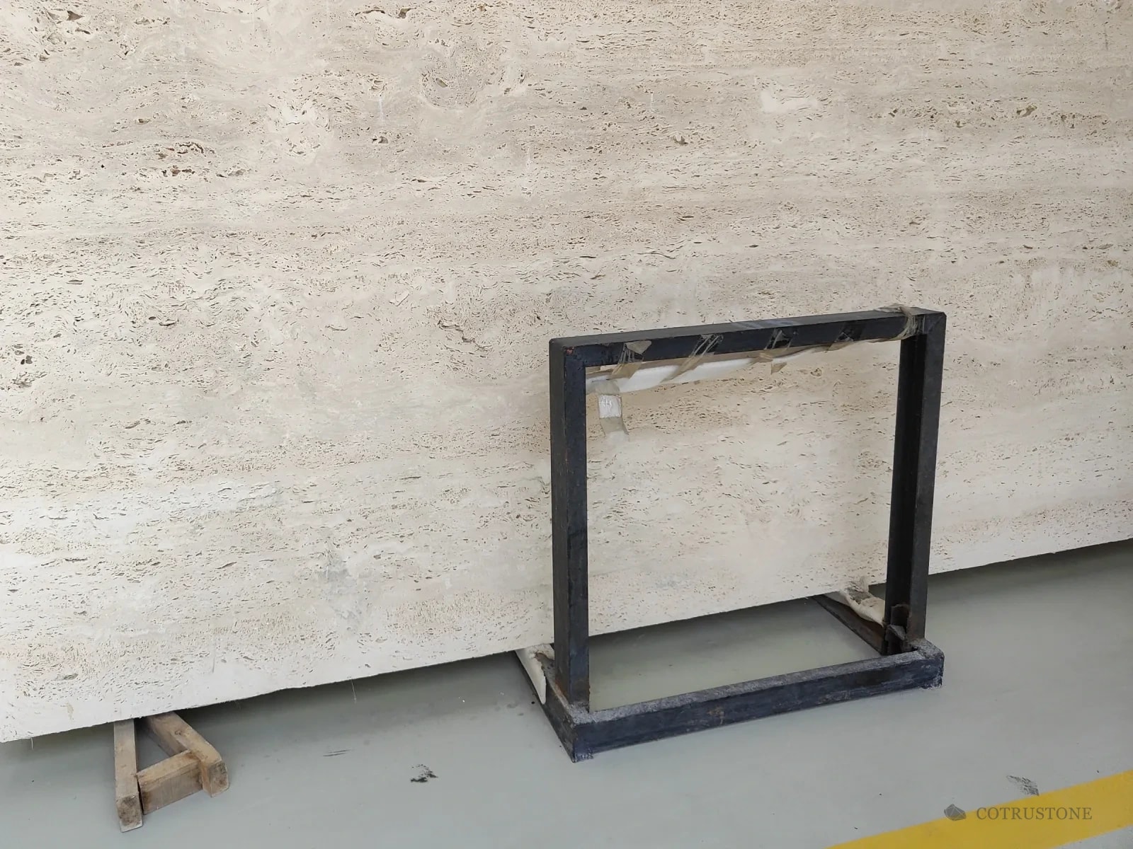 A slab of Italian Ivory travertine on a stand, vein cut
