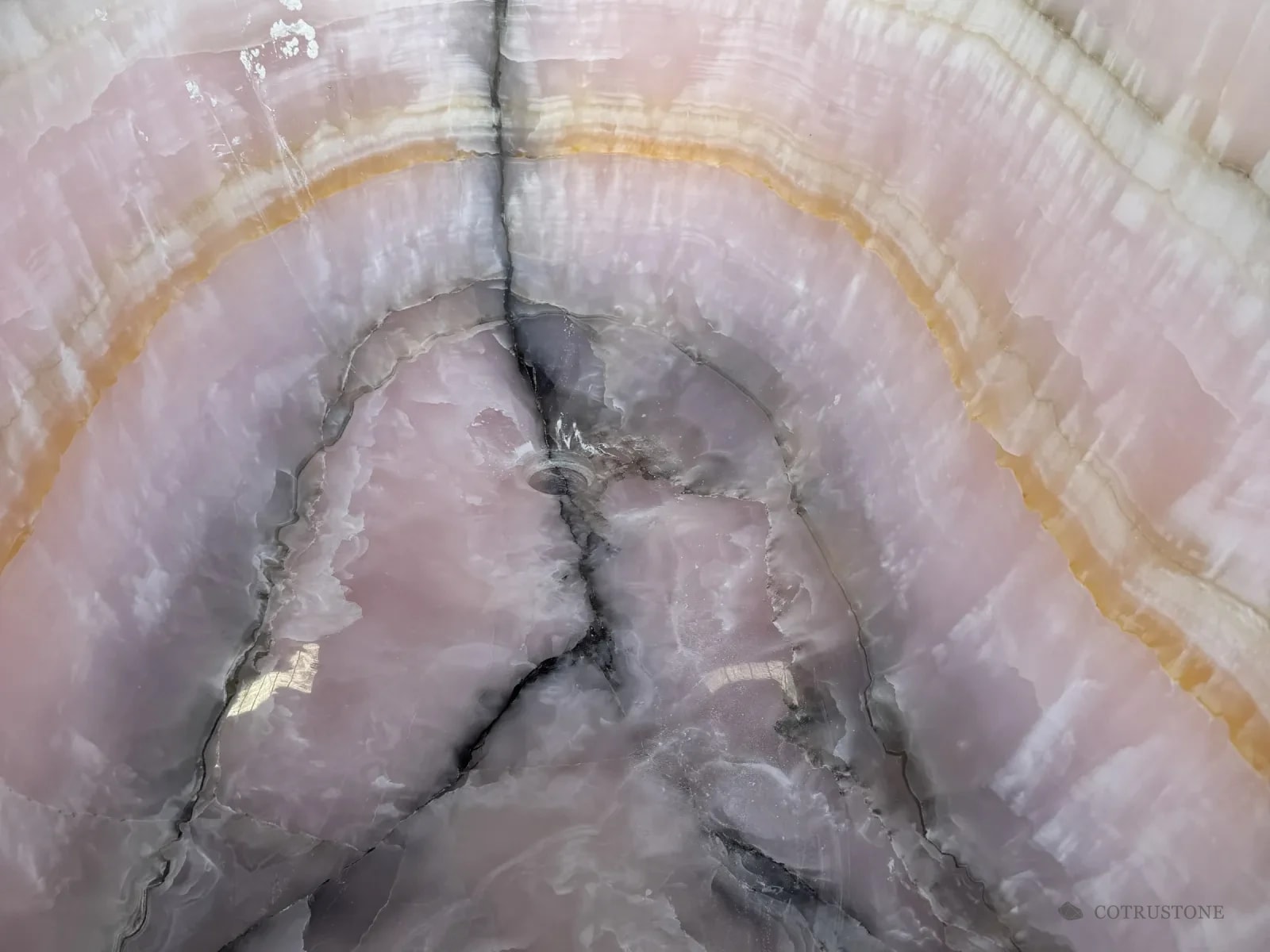 Close view of a pink onyx block with ivory bands
