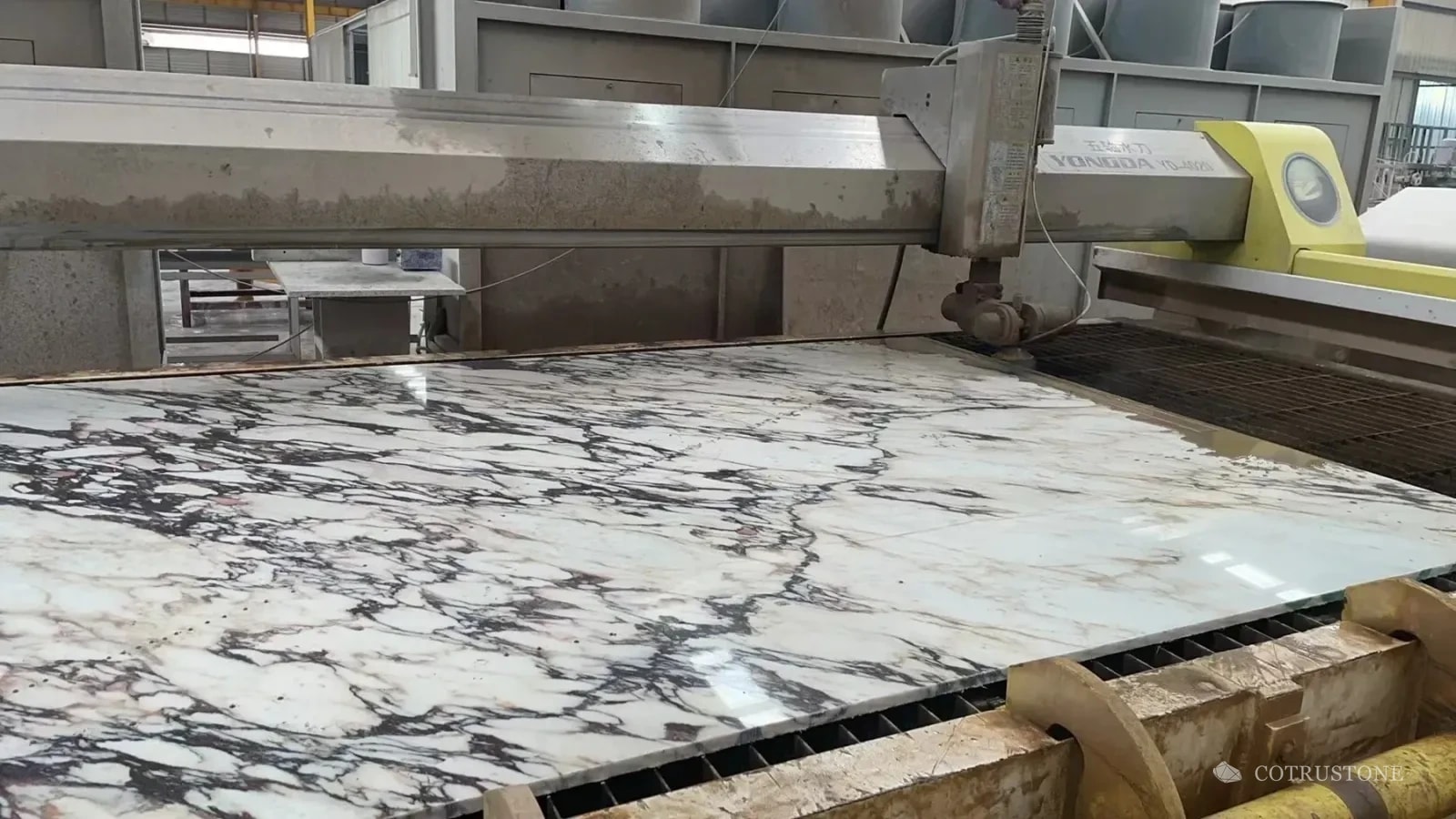 Veined stone slab on a cutting table during fabrication