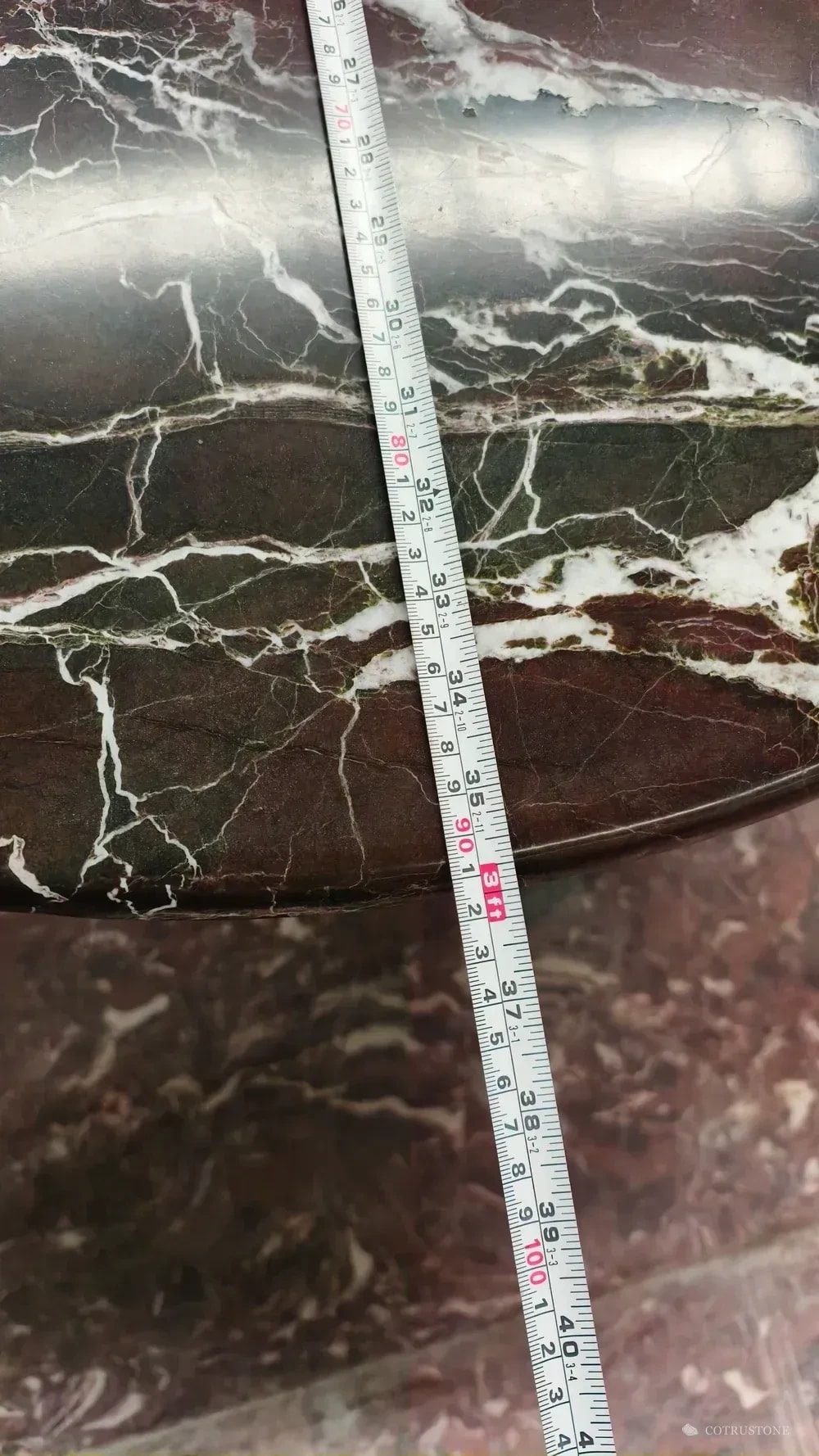 Tape measure laid across a veined stone tabletop during dimensional checking