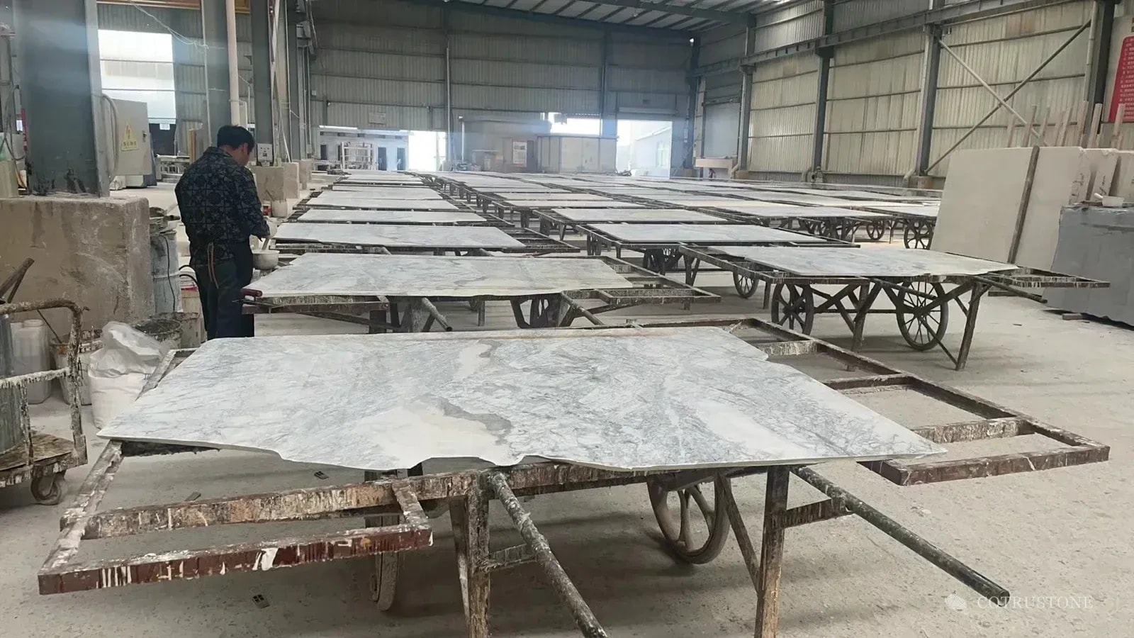 Stone pieces arranged across workshop benches for processing