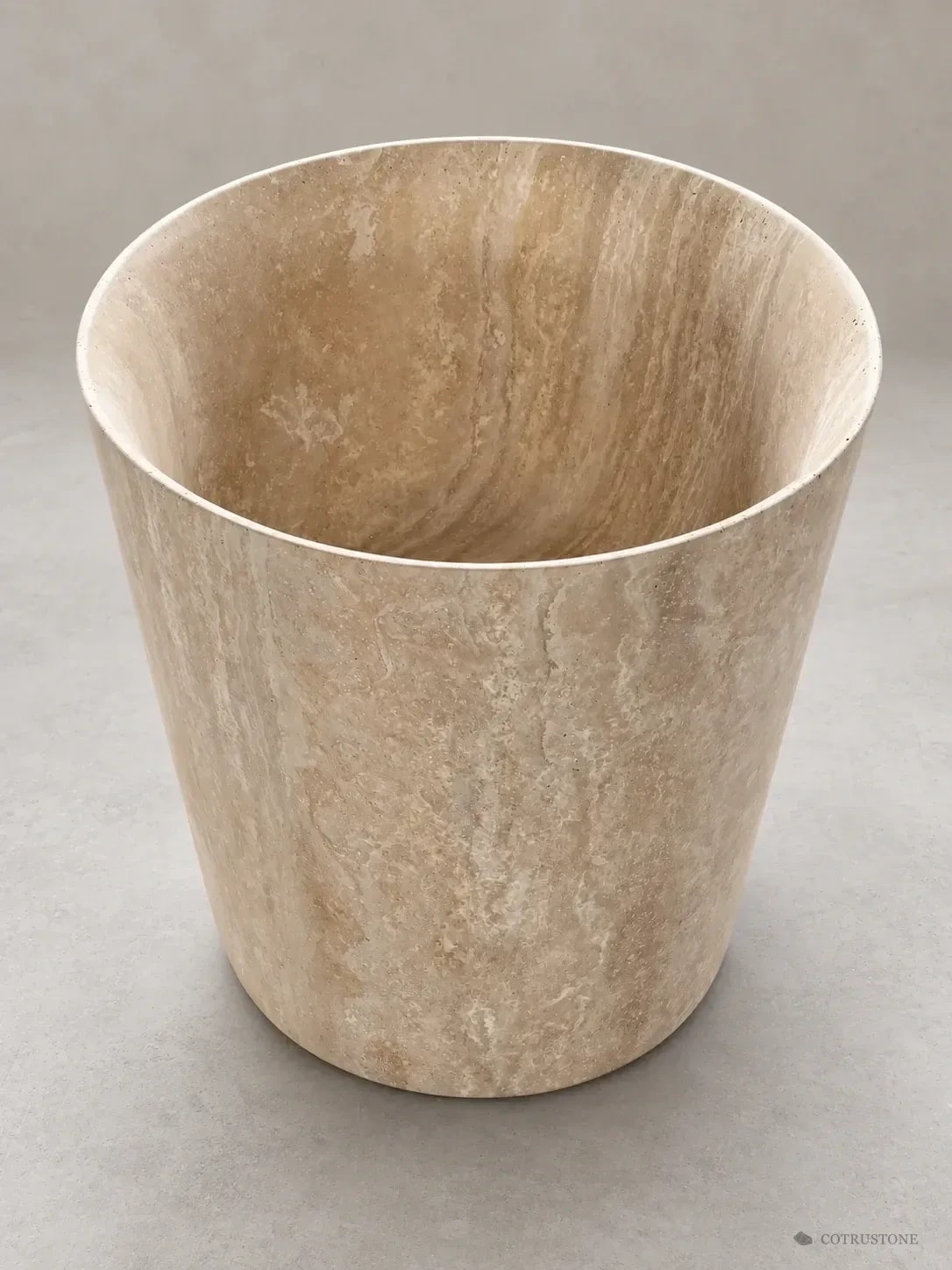 Tapered travertine pedestal basin with continuous natural veining and a wide oval bowl