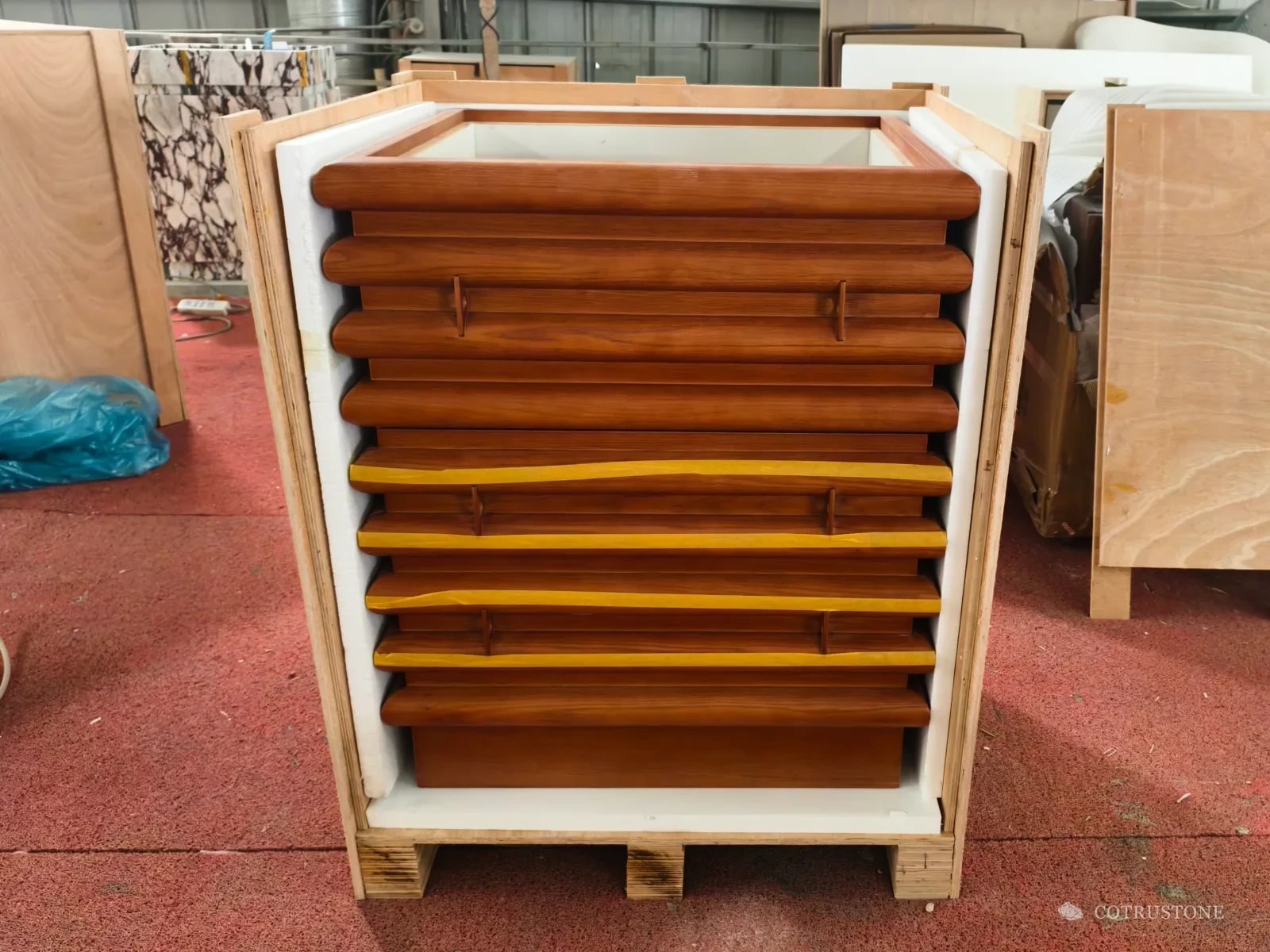 Timber vanity cabinet lined with foam inside an open timber shipping crate