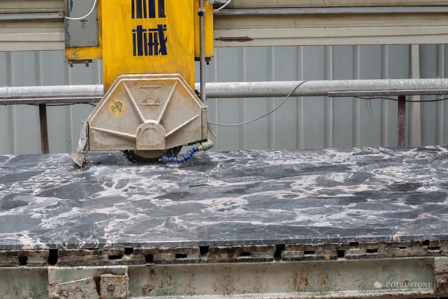 Bridge saw cutting a selected marble slab
