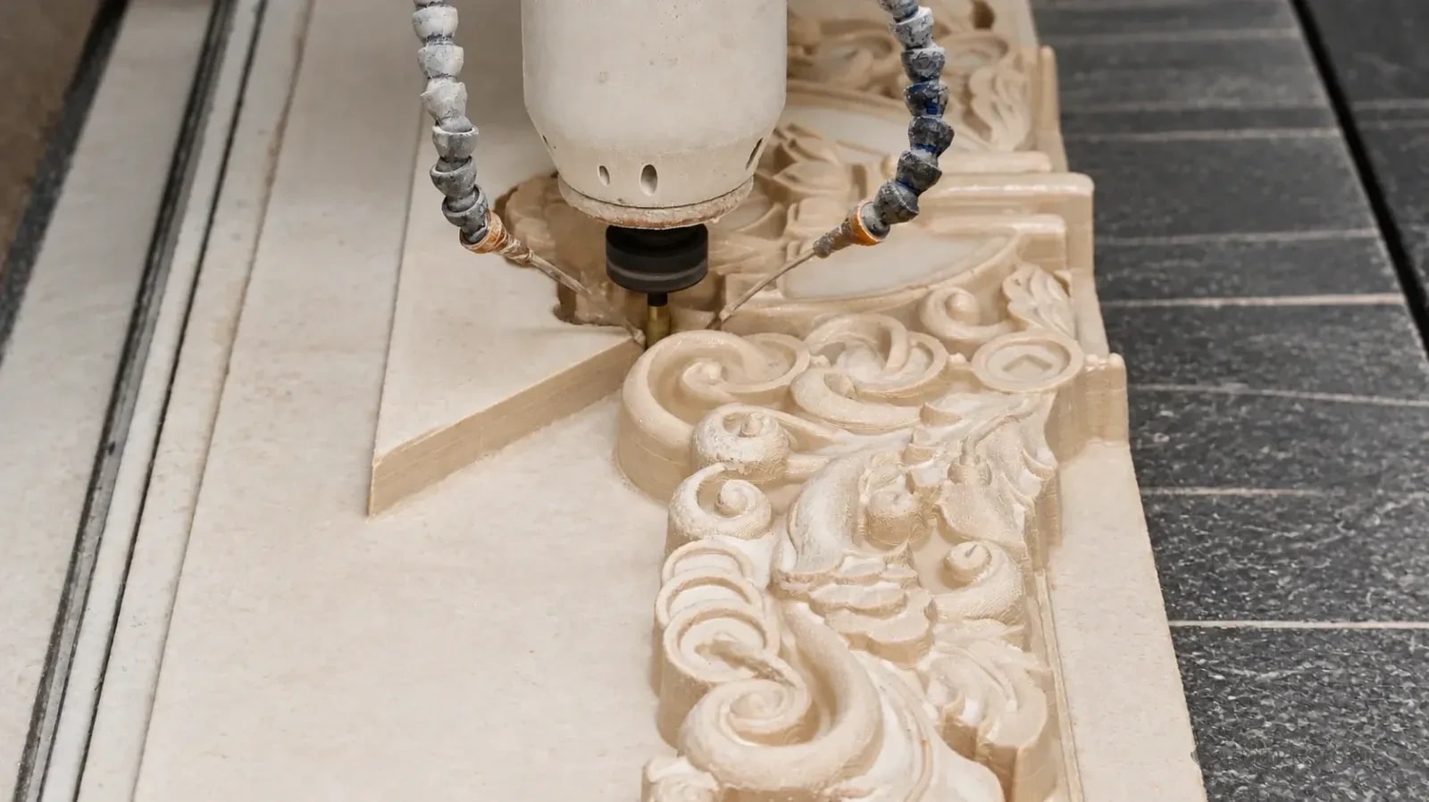 Machining head shaping a floral stone relief