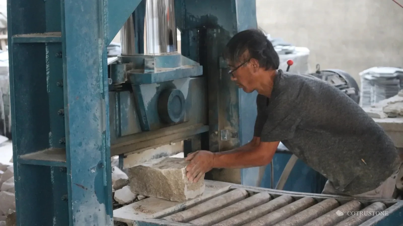 Worker positioning stone at a splitting machine